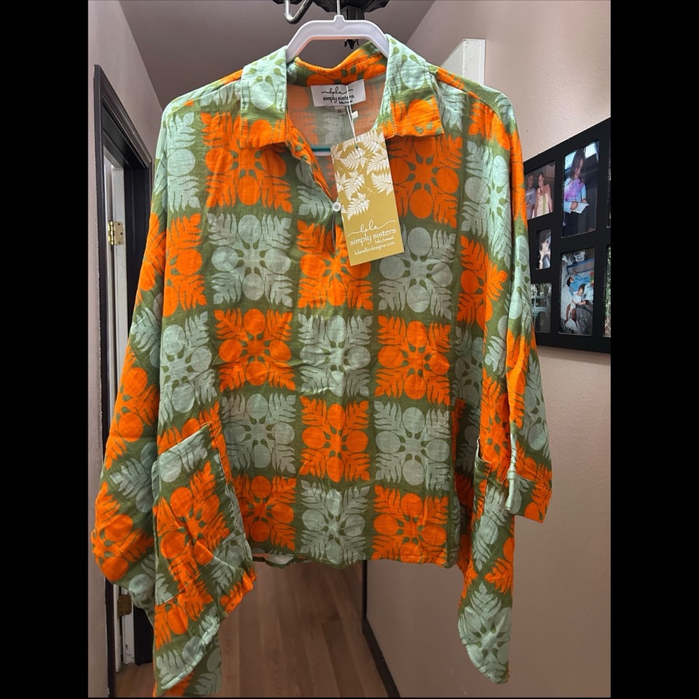 Button at top. Loose fit. Pockets in front.